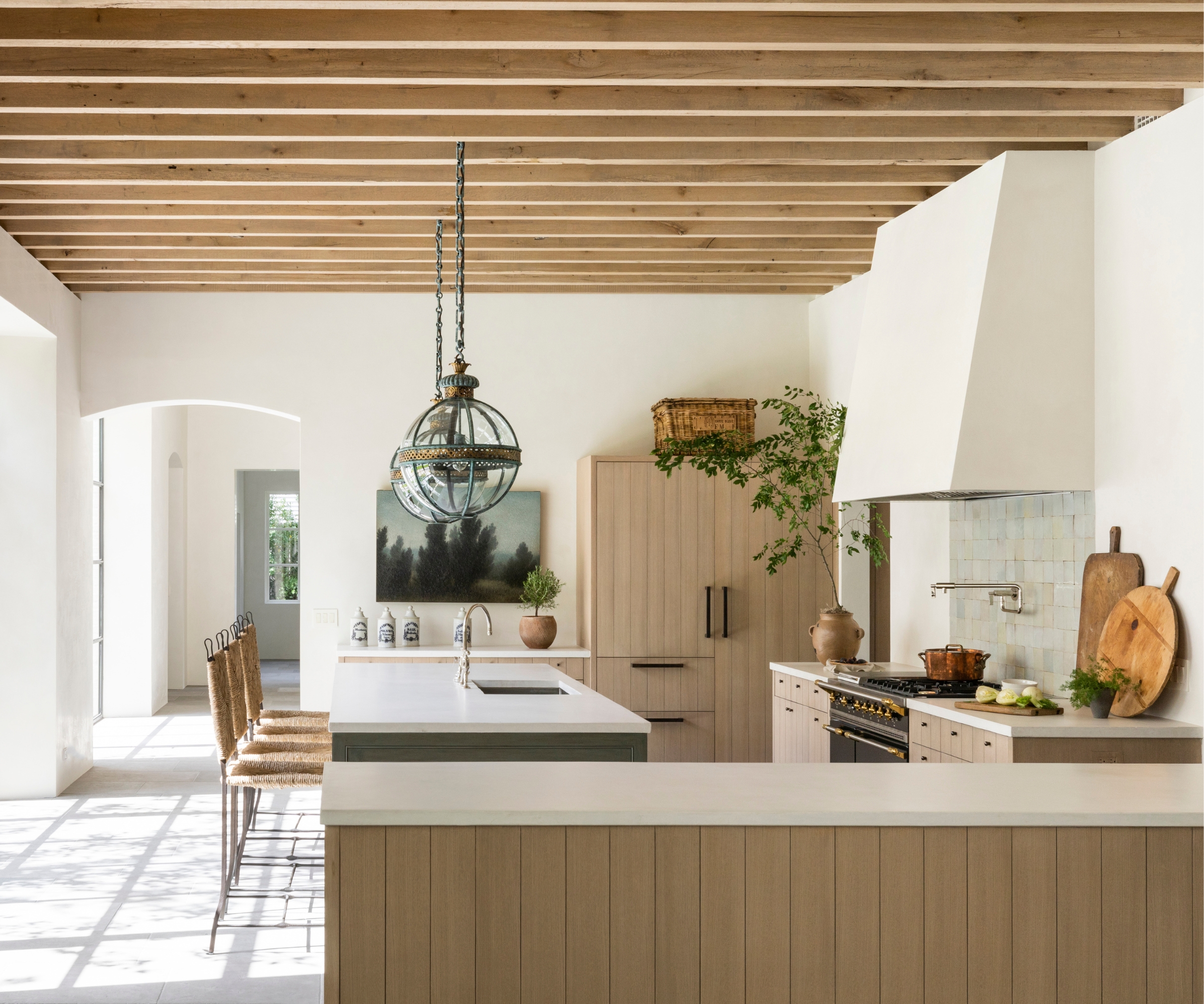 neutral kitchen with wood paneled cabinets, white walls, and collected decor