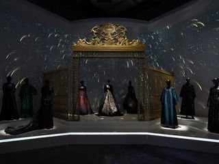 Mannequins modelling ball gowns and full-length coats against a backdrop of shooting stars