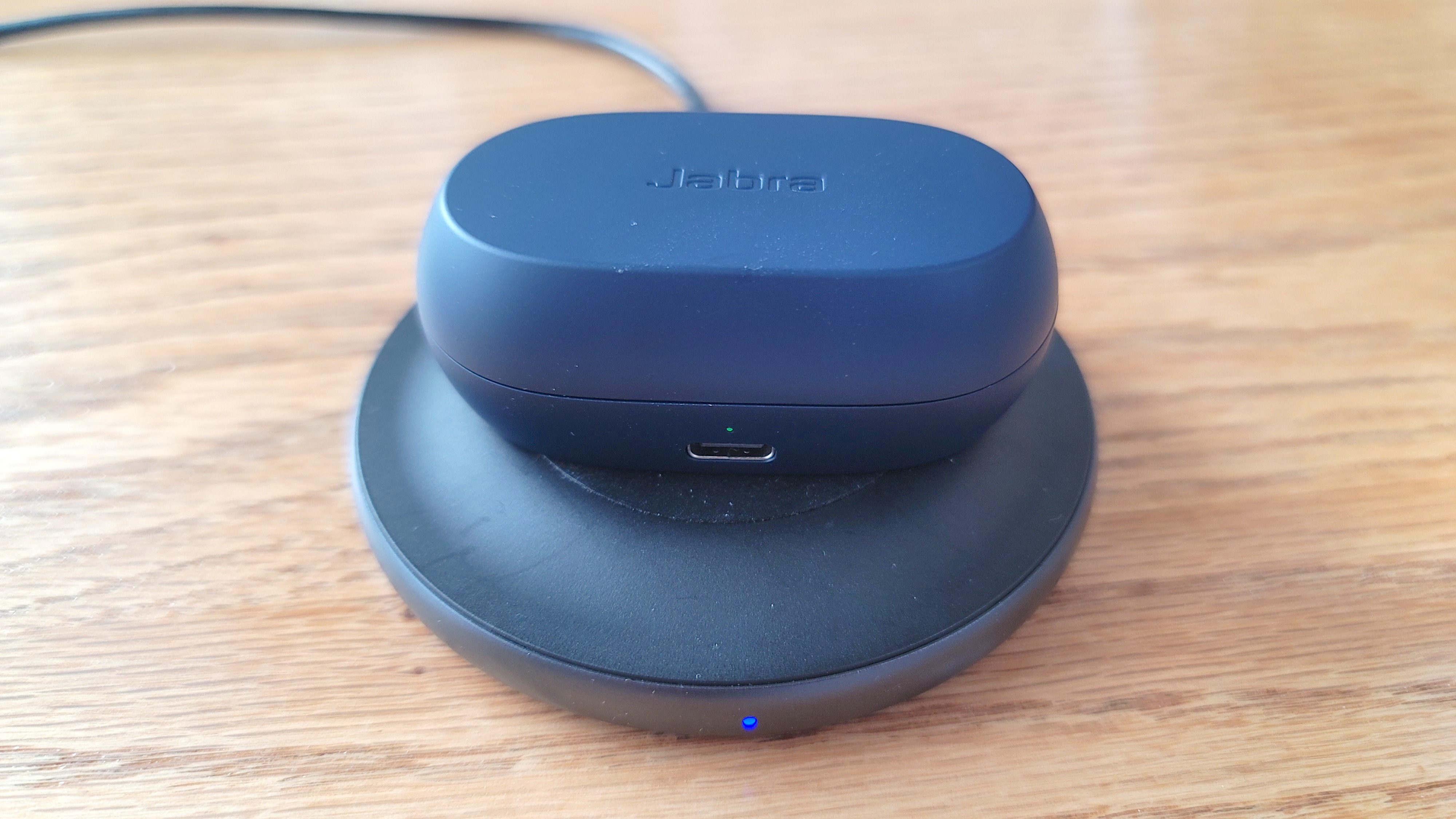 The Jabra Elite 7 Active charging on a wireless charging pad