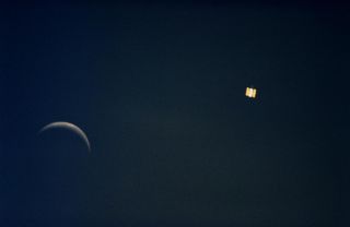 An image taken during the first servicing mission, in 1995, shows the moon on the left and the Hubble Space Telescope on the right.