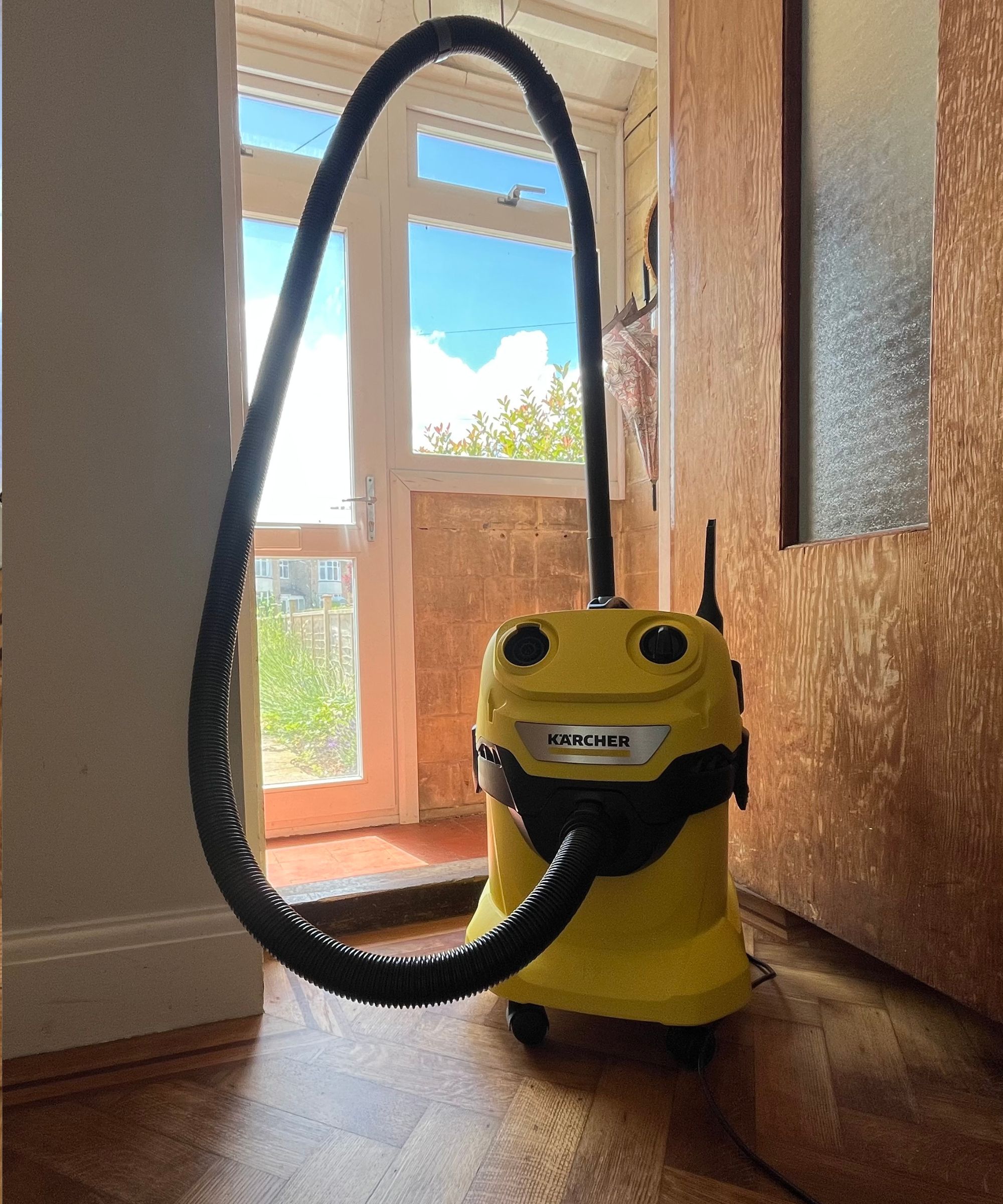 Karcher WD4 on hard wood flooring in front of the door to the porch, with tools onboard for storing.