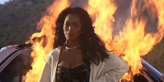 Angela Bassett in front of a burning car