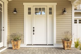 A front porch of a beige weatherboard house painted