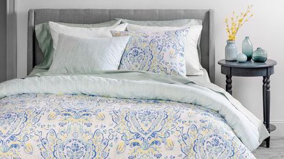 Martha Stewart Yasmin Duvet Cover on a bed beside a nightstand.