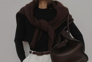 Woman in black and brown sweater with large leather bag