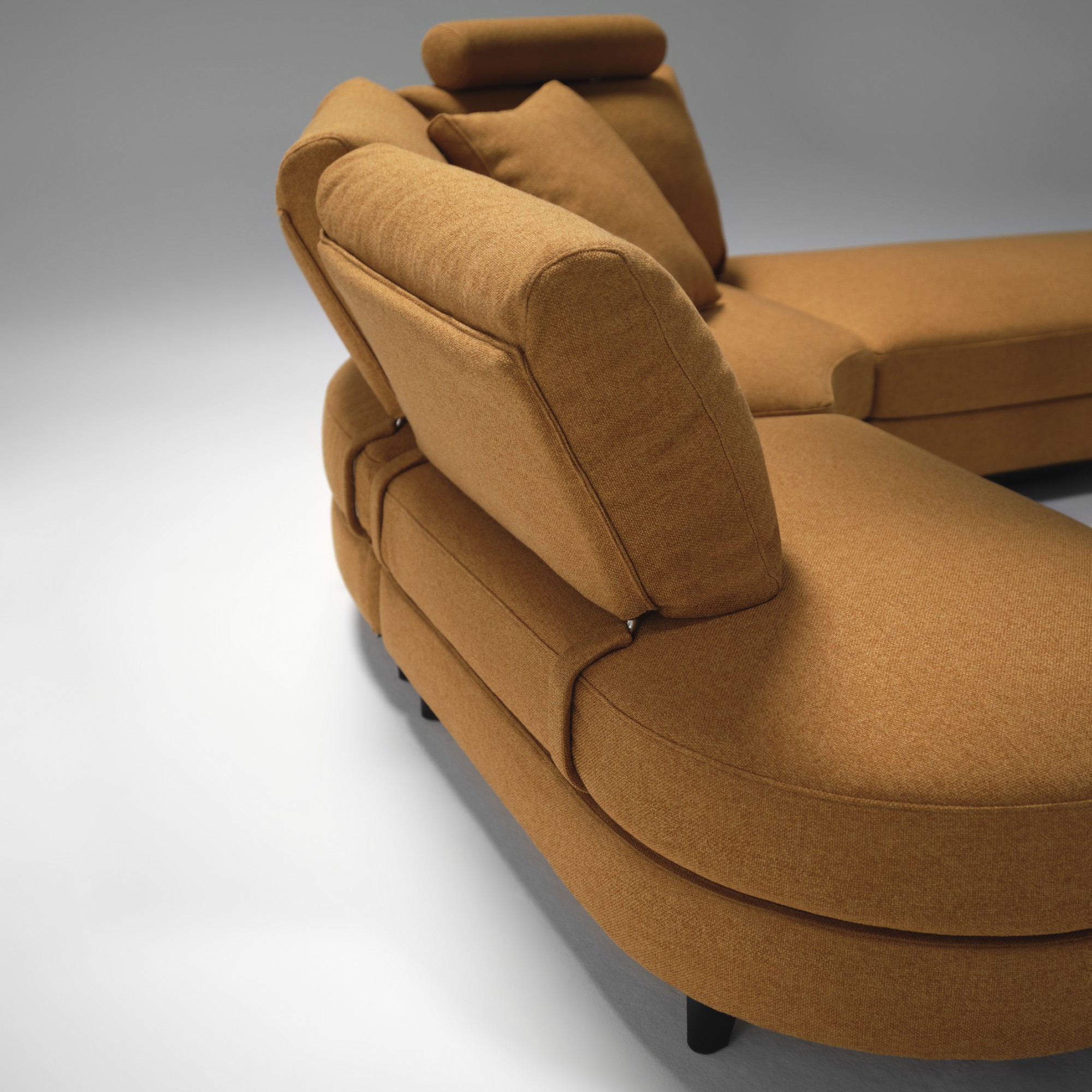 The back of the curved King Living Delta 5 storage sofa in orange in a studio setting