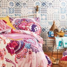 bedroom with printed walls and bed with alladin printed bedding set
