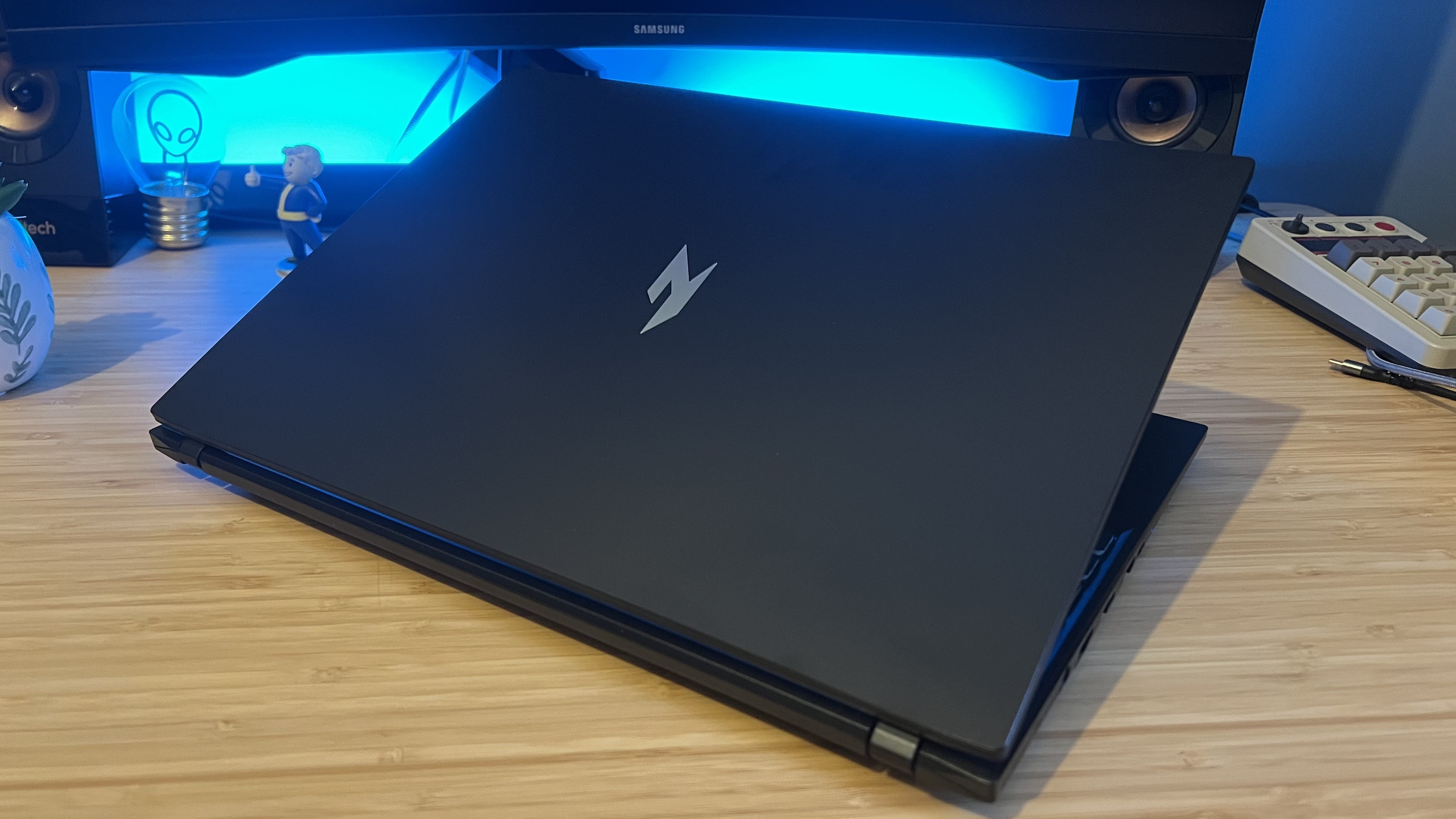 Acer Nitro V 16 AI gaming laptop with lid half closed on a wooden desk