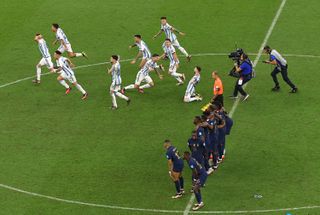 Argentina players run to celebrate after beating France on penalties in World Cup 2022 final.