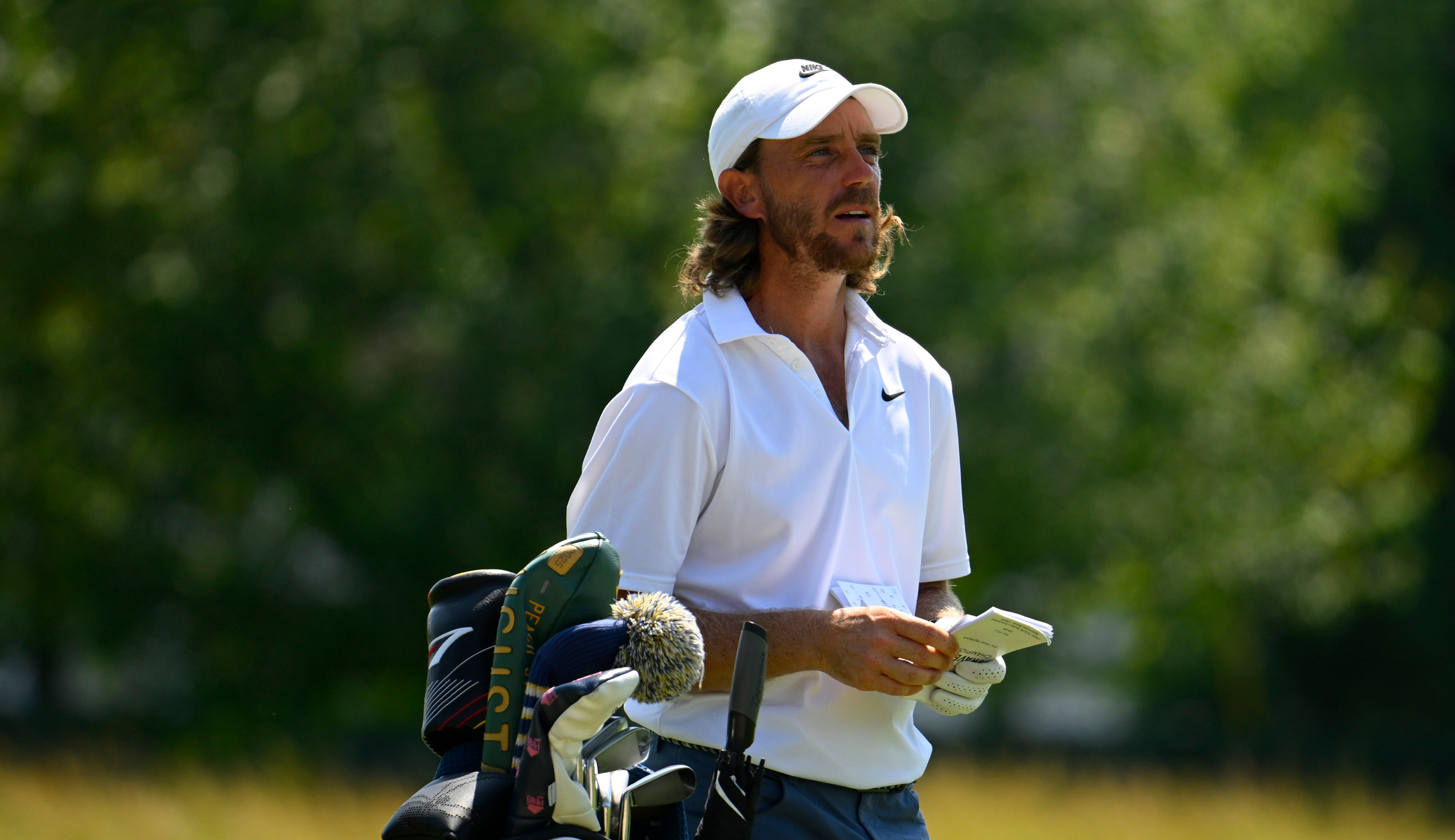 Tommy Fleetwood walks by his bag