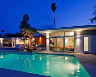 swimming pool at night with fairylights around nearby tree