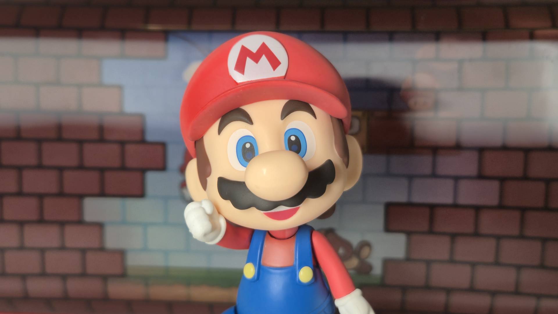 Photo of the Super Mario Nendoroid toy by Good Smile Company sitting in front of the Turtle Beach Mario Bricks Switch 2 case.