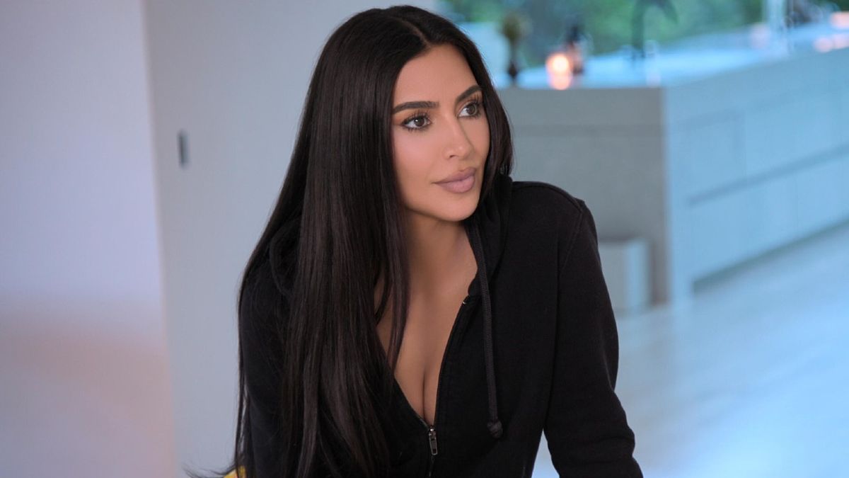 Kim Kardashian wearing a black zip up hoodie and looking to her right in The Kardashians. 