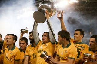 Tim Cahill lifts the Asian Cup alongside his Australia team-mates after victory over South Korea in the 2015 final.