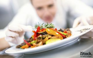 Female chef places finishing touches on meal by gilaxia