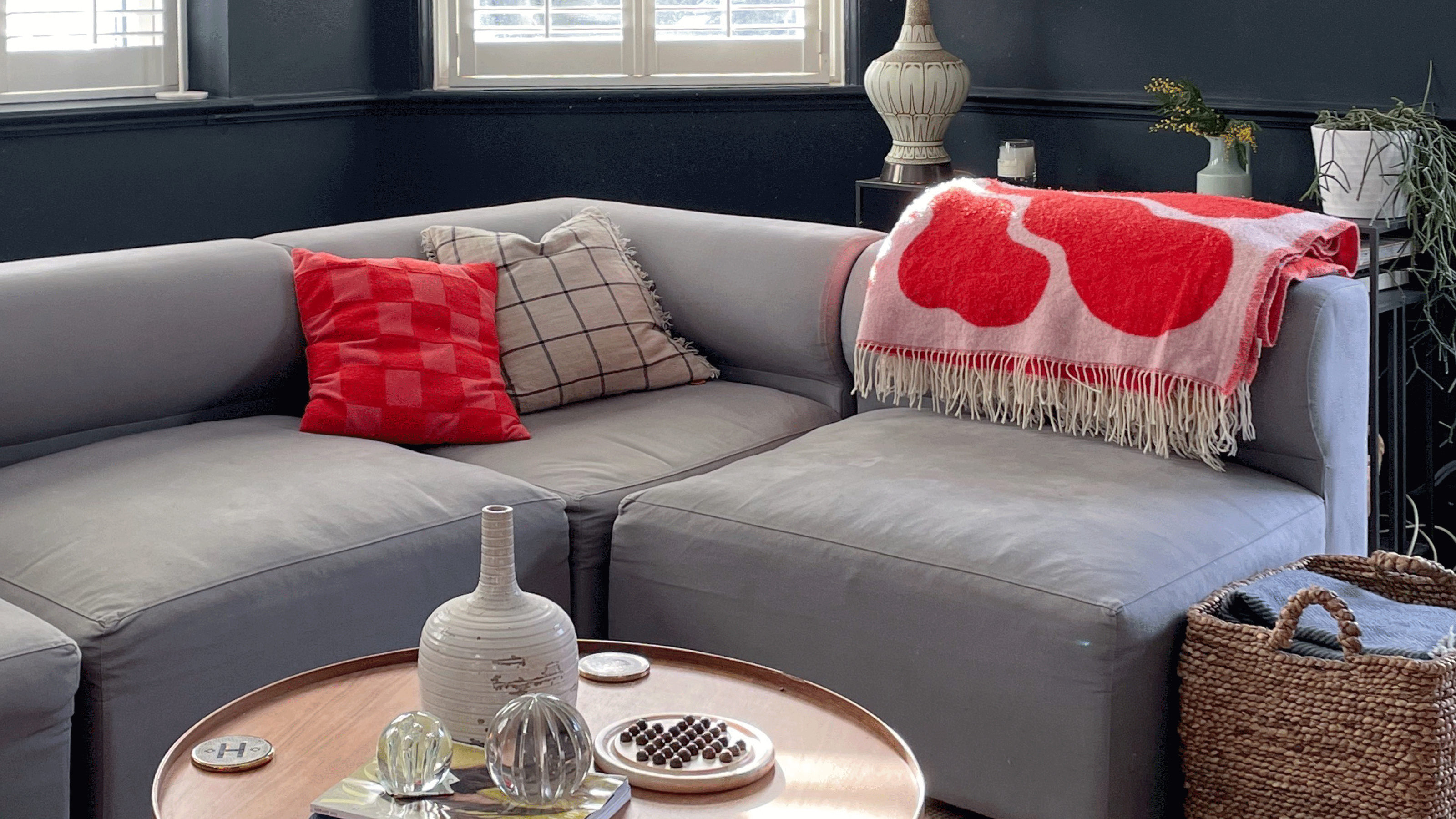 black living room with grey sofa and pink blanket