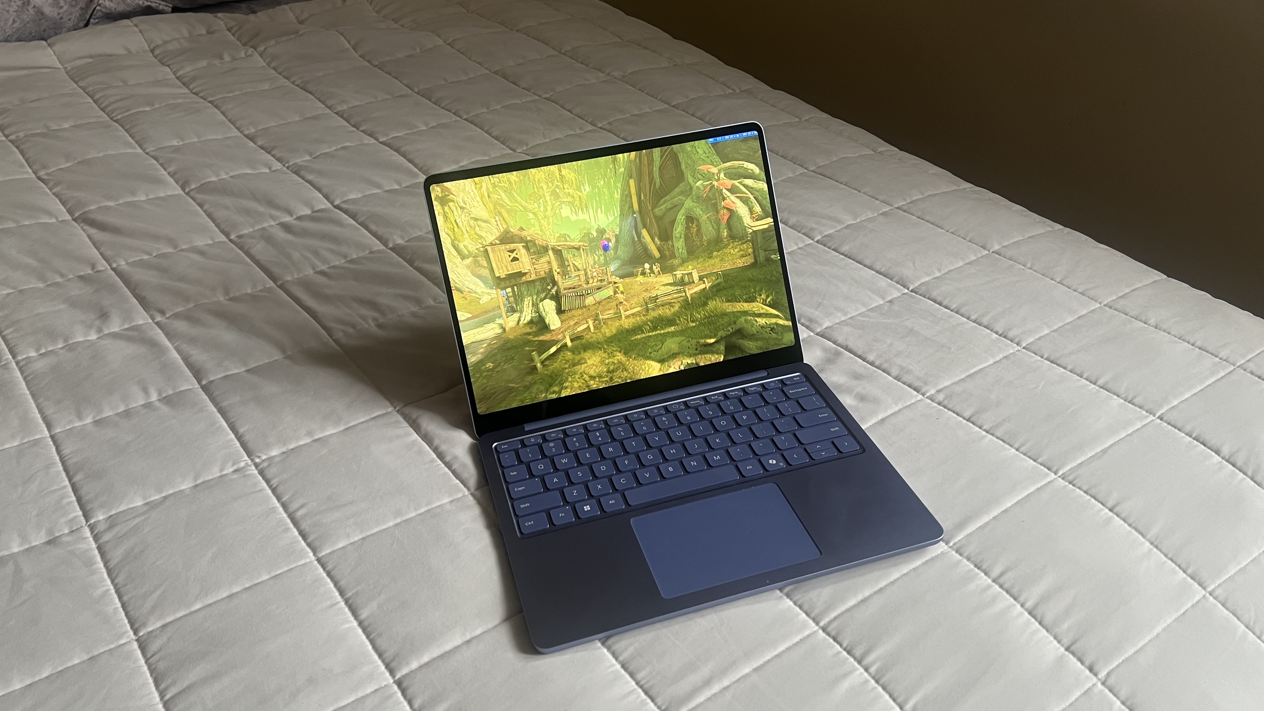 A Microsoft Surface Laptop 13-inch on a bed