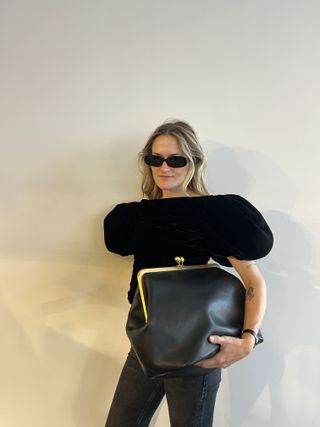 Woman holding the Coach oversize coin purse.