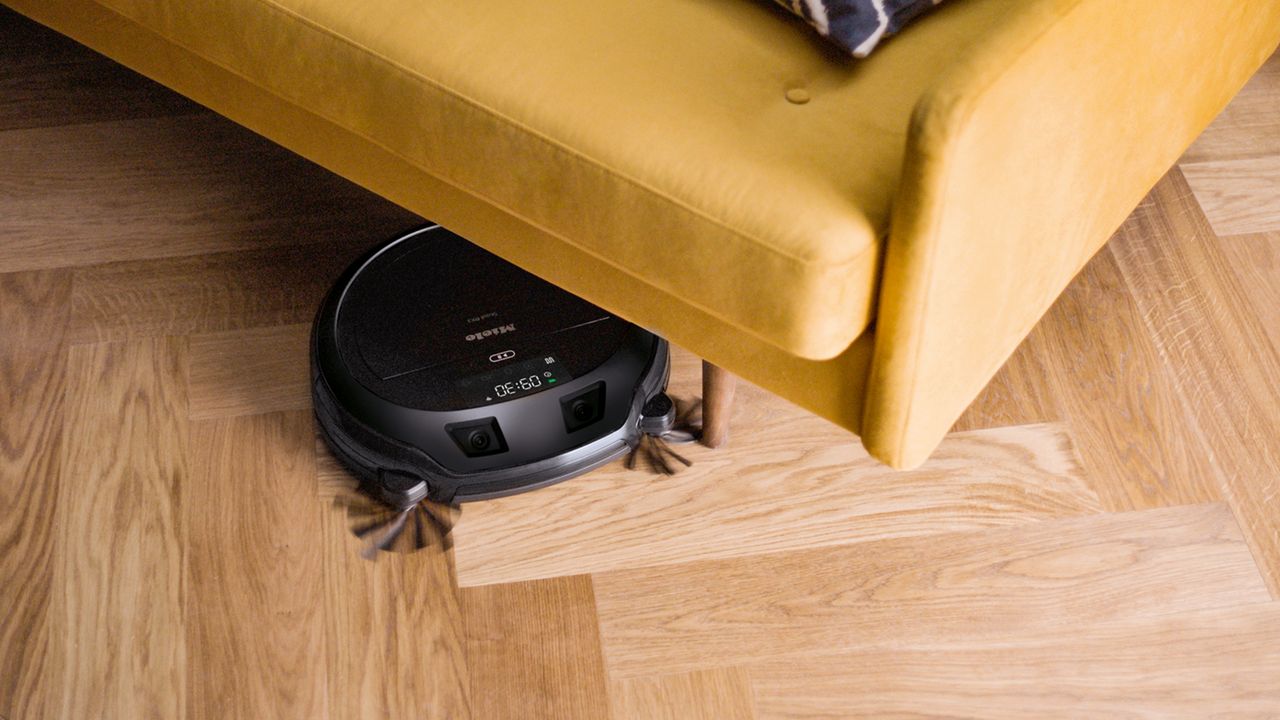 Robot vacuum cleaner under yellow sofa