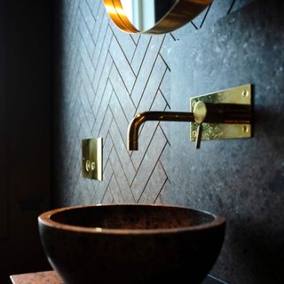 Close up of round copper basin with blue wall