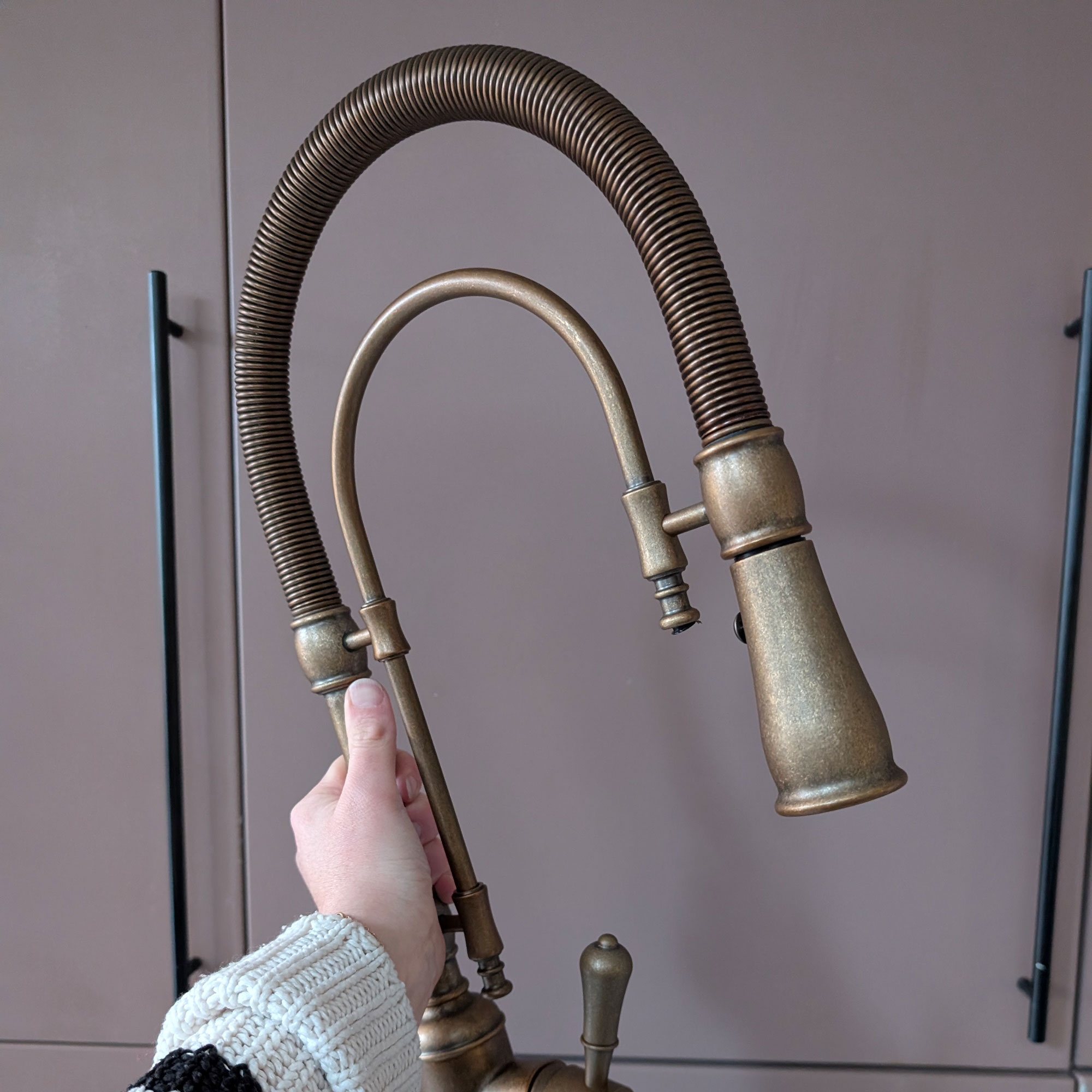 Curved brass hose tap being held up