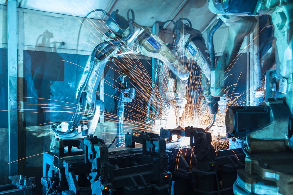 Image of a robot arm building equipment in an automated factory