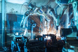 Image of a robot arm building equipment in an automated factory