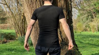 Rear view of man wearing short-sleeved base layer in front of tree