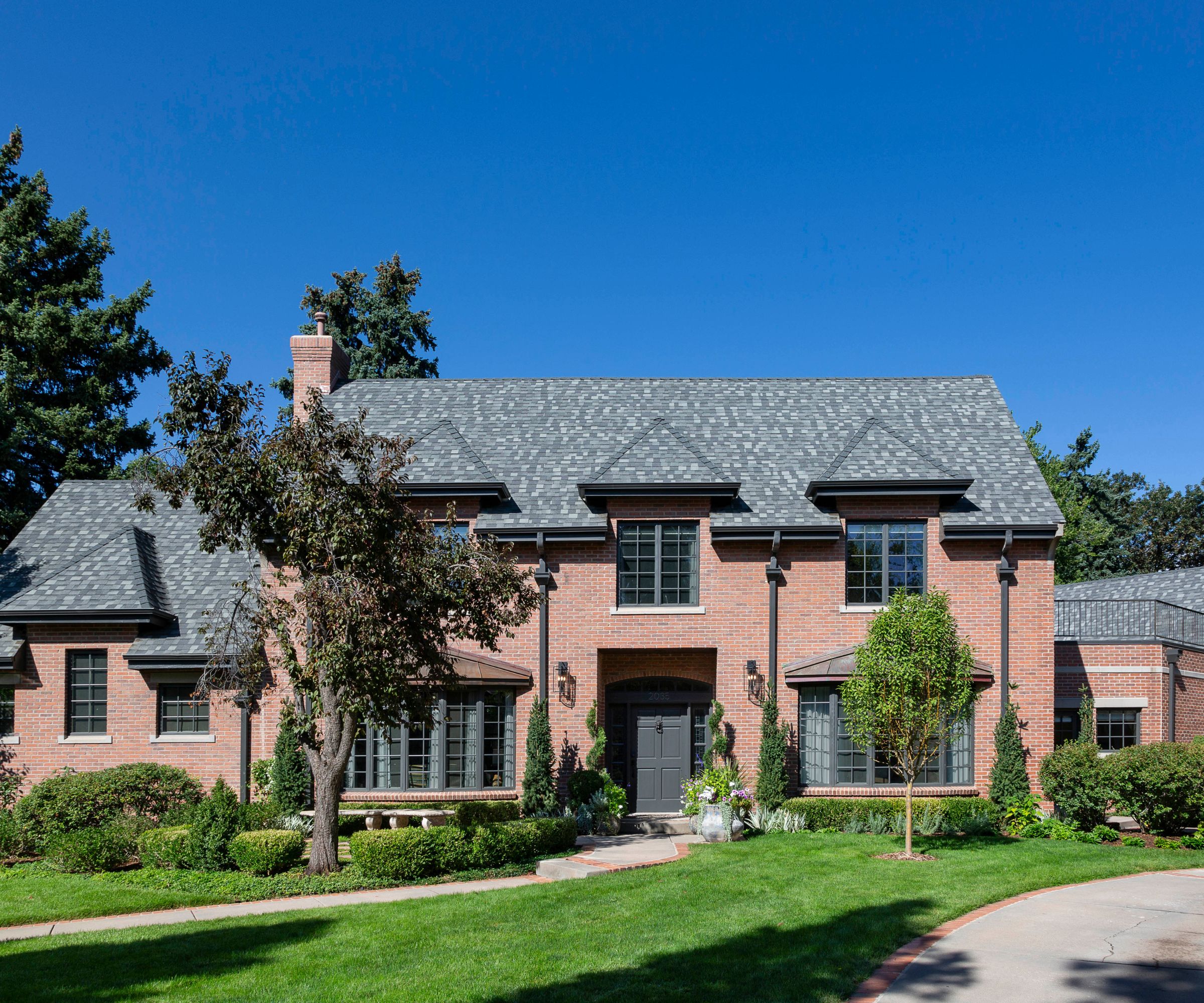 Exterior of a red brick home with gray tiled roof