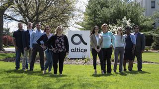 Employees gather in front of Altice USA's Bethpage, N.Y., corporate campus