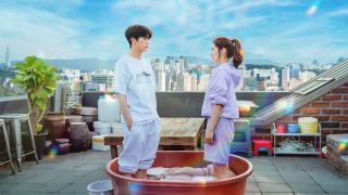 two people (Park Hyung-sik and Park Shin-hye) stand in a washing tub on a Seoul rooftop, in Netflix k-drama 'Doctor Slump'
