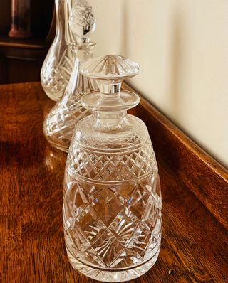 Row of three crystal vases on wooden buffet