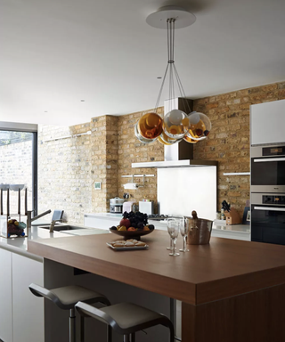 Statement kitchen lighting idea above a wooden island.