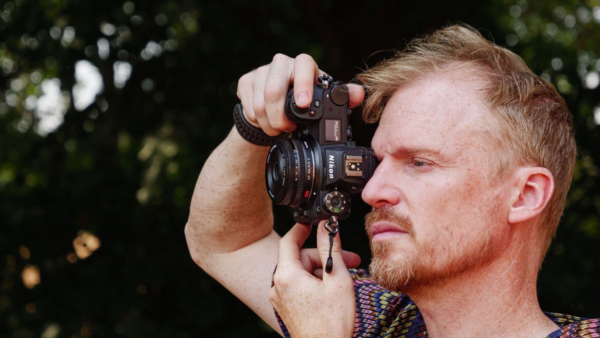 Viltrox AF 26mm F2.8 EVO 'pancake' lens attached to a Nikon mirrorless camera, photographer and TechRadar's Cameras Editor, Tim Coleman is holding the camera up to his eye