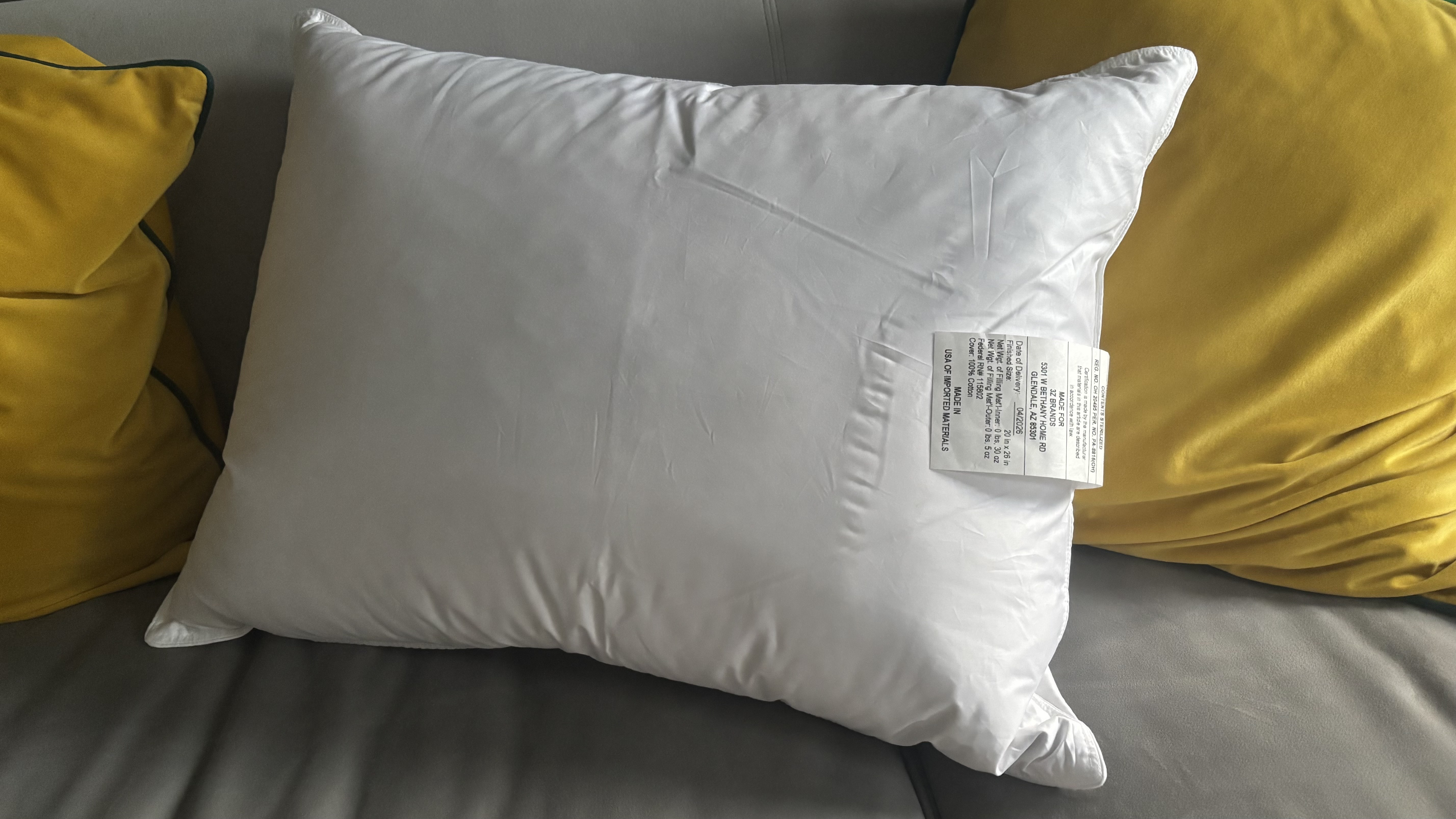 The Helix Down and Feather Pillow on a grey couch.