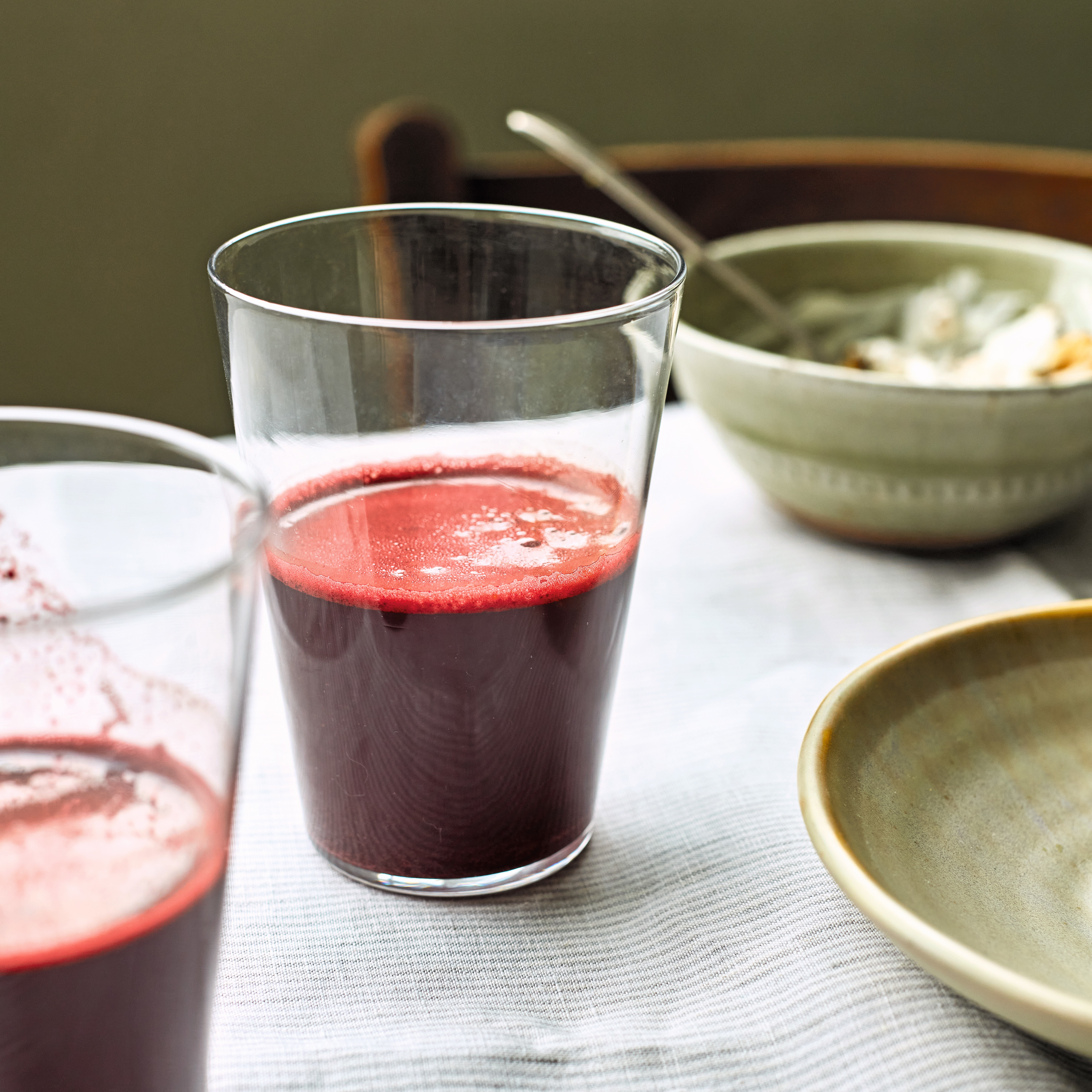 Glass of beetroot-red smoothie on table