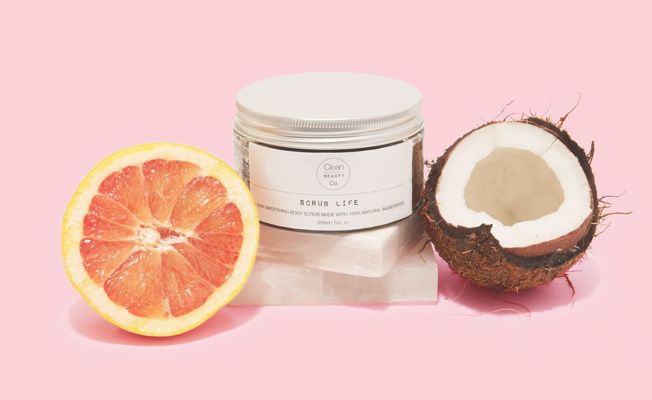 Jar of &quot;SCRUB LIFE&quot; body scrub, next to a cut grapefruit and a coconut