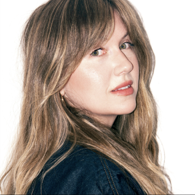 a headshot of a white woman with blonde hair wearing peach lipstick
