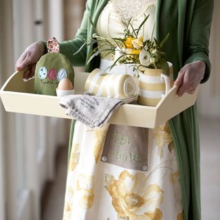 lady wearing retro floral apron holding tray