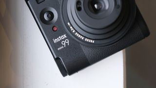 Fujifilm Instax Mini 99 instant camera on a white surface