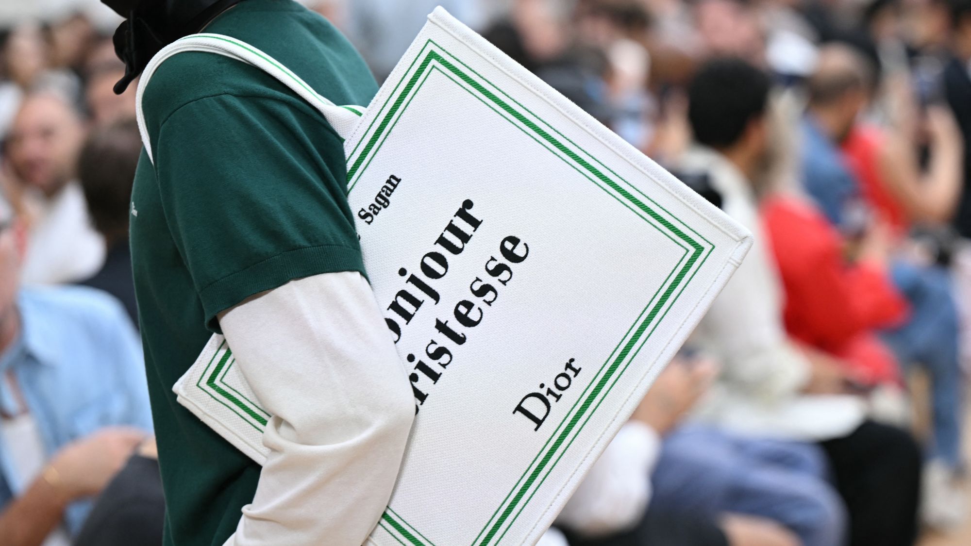 a model at dior homme ss26 wearing a book tote