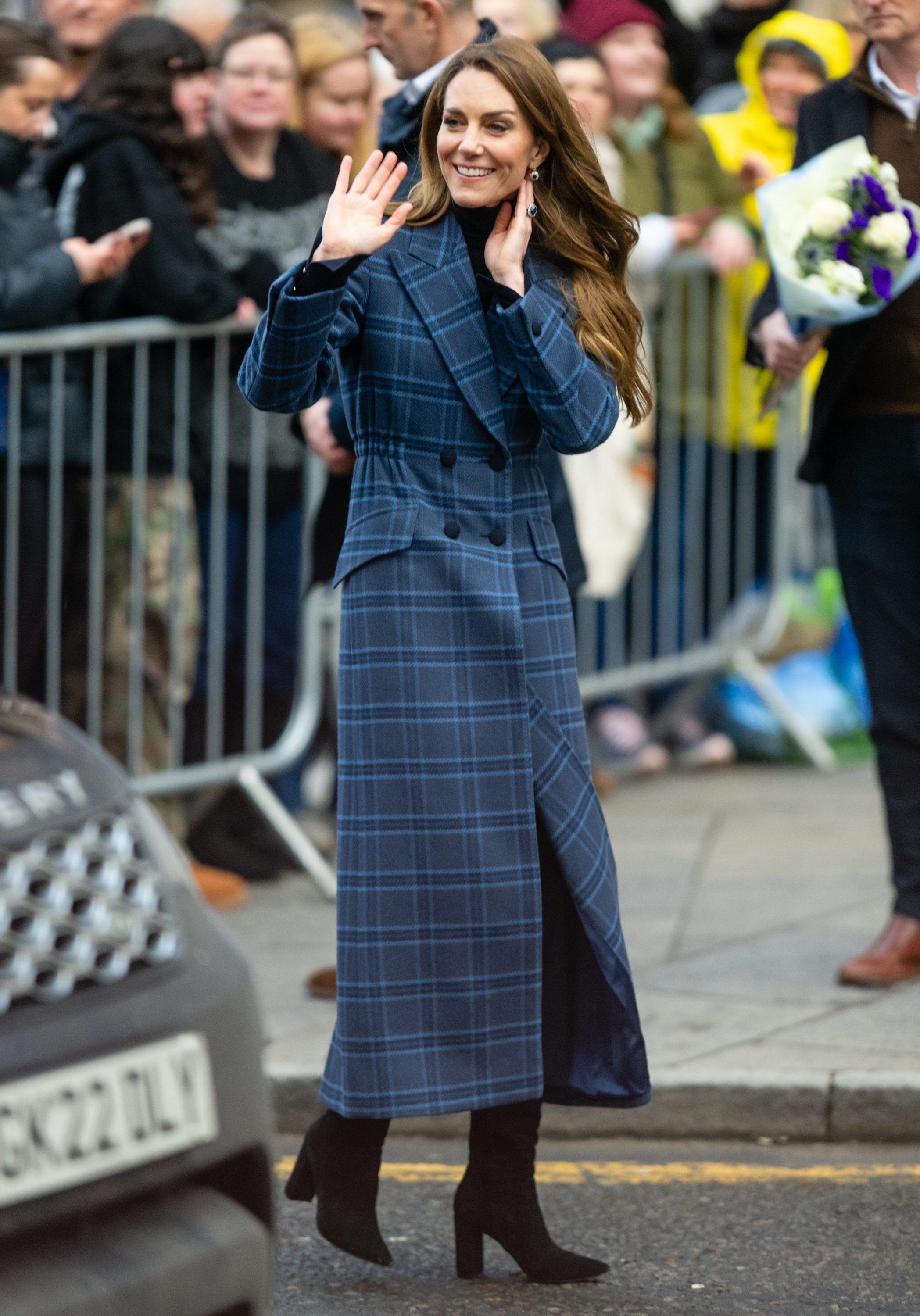 Princess Kate wearing a blue tartan coat and waving