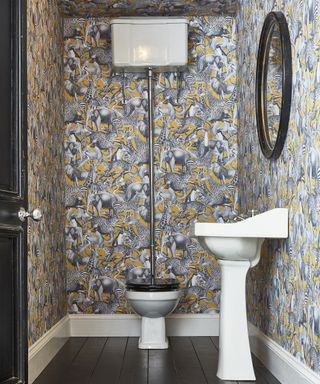 Grey and yellow animal motif wallpaper in downstairs toilet by Graham & Brown