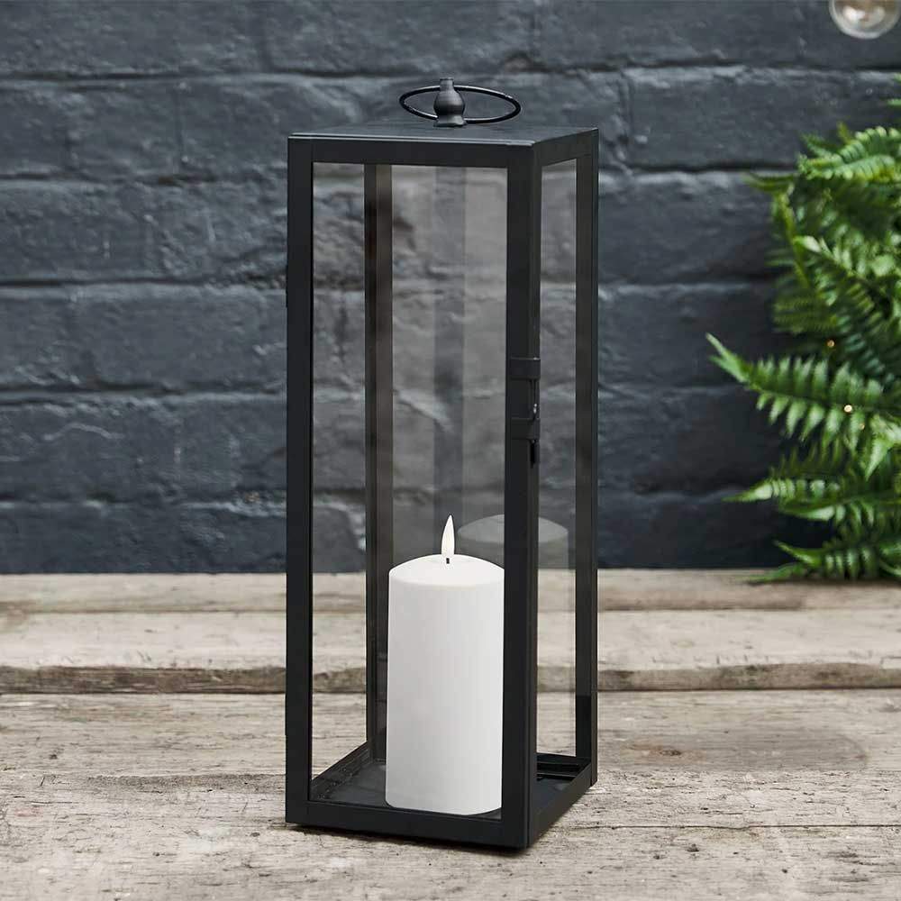 Black metal outdoor lantern with LED candle to show the quiet luxury garden trend