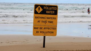 Pollution warning sign on a beach