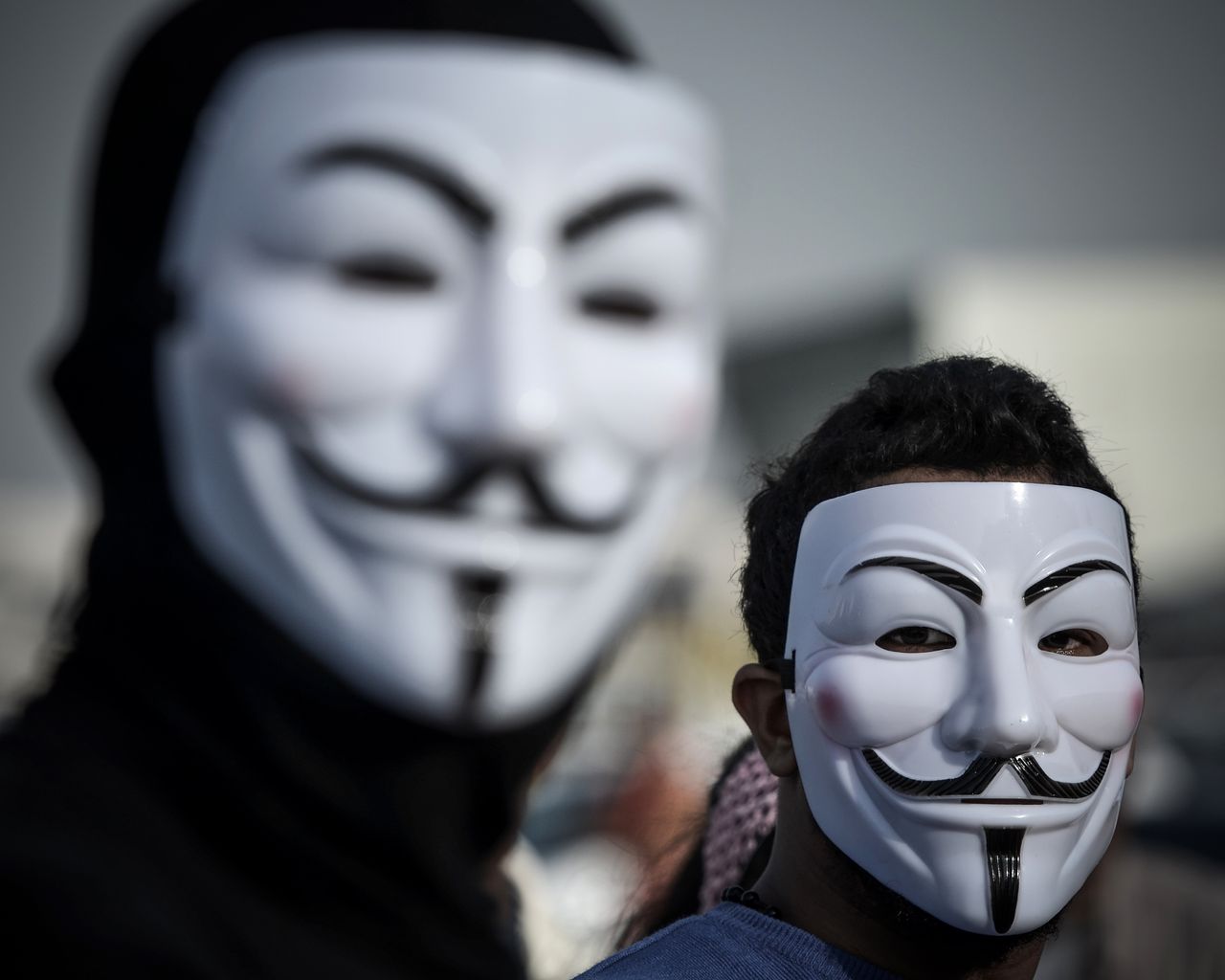 Demonstrators wearing masks used by the Anonymous movement