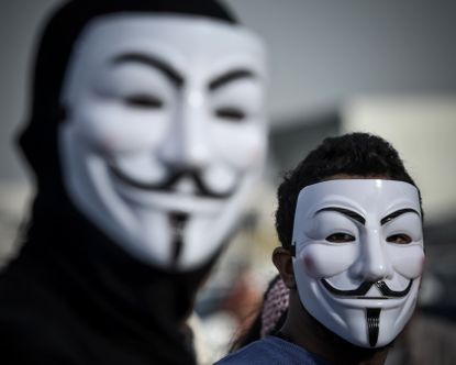 Demonstrators wearing masks used by the Anonymous movement