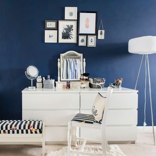 bedroom with frames on blue wall and mirror