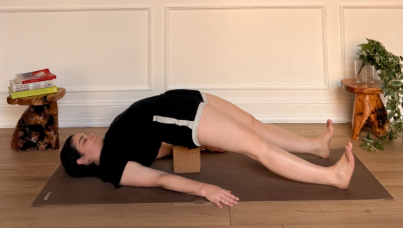 Purdon showing supported bridge pose on yoga mat