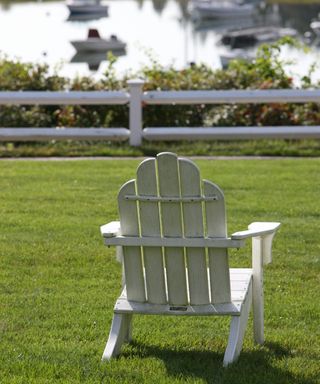 a white wooden lawn chair on a lawn